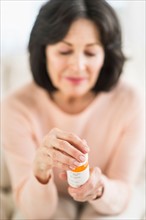 Senior woman holding pill bottle.