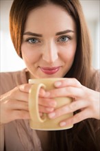 Portrait of young woman holding coffee cup