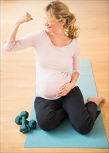 Pregnant woman exercising on mat