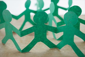 Human silhouettes cut out from green paper