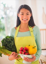 Teenage girl with bunch of vegetables in kitchen