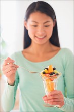 Teenage girl eating fruit dessert