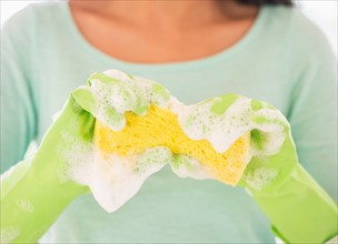 Teenage girl wearing rubber gloves with washing sponge