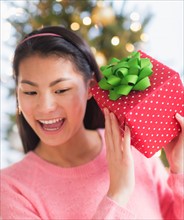 Front view of teenage girl ( 16-17 years) holding Christmas gift