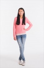 Portrait of teenage girl ( 16-17 years) wearing jeans and pink sweater