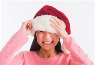 Portrait of teenage girl (16-17 years) wearing santa hat