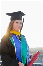Portrait of graduate student holding diploma
