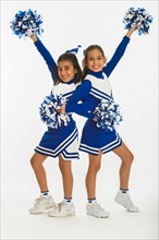 Portrait of cheerleaders (8-9 years) ( 10-11 years) holding pom-pom