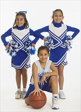 Portrait of cheerleaders (8-9 years) ( 10-11 years) holding pom-pom and ball