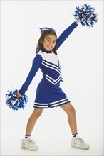 Portrait of cheerleader ( 8-9 years) holding pom-pom