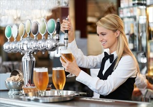 Female bartender pouring beer
