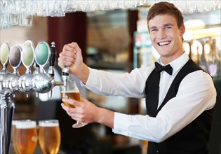 Portrait of bartender pouring beer