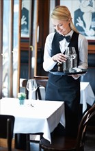 Portrait of young waitress setting table