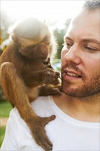 Portrait of man holding monkey
