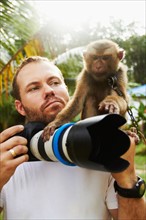 Portrait of man with camera and macaque monkey