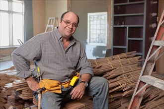 Man sitting on stack of planks
