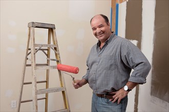 Portrait of man holding paint roller