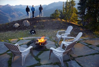 Three people standing near fire pit looking at landscape