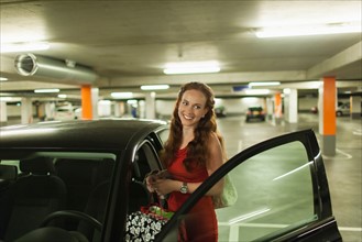 Young woman standing next to open car door