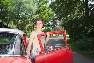 Portrait of elegant woman next to vintage car