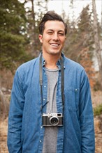 Portrait of young man with old fashioned camera in non-urban scene