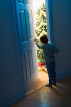 Boy (4-5) peeking through doorway.