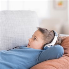 Boy (4-5) listening to music on headphones.