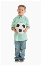 Portrait of boy (4-5) holding soccer ball.