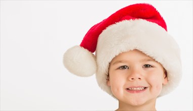 Portrait of boy (4-5) wearing santa hat.