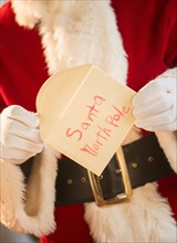 Santa claus holding letter.