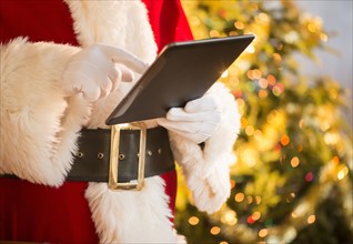 Santa claus holding digital tablet.