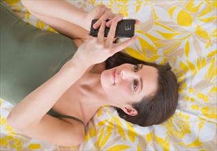 Woman lying on bed and texting.
