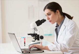 Scientist looking through microscope.
