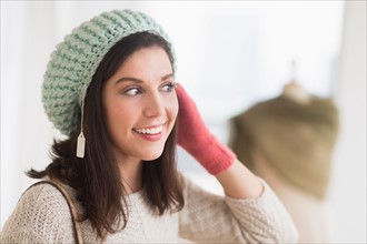 Woman trying on knit hat.