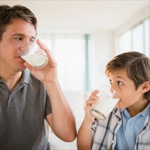 Father and son (8-9) drinking milk