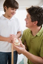 Father explain son (8-9) how to play baseball