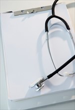 Studio shot of stethoscope and clipboard with blank paper