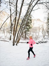 Woman jogging in winter forest