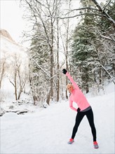 Woman exercising in winter forest