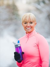 Female athlete drinking water outdoors