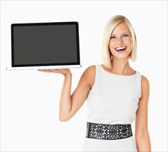 Studio portrait of young woman holding laptop
