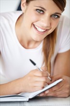 Portrait of young woman writing in notepad
