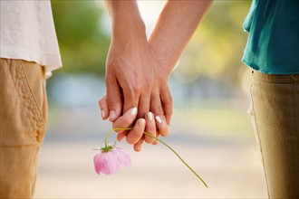 Couple holding hands and flower