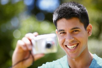Portrait of young man using digital camera