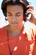 Portrait of young man listening to music with headphones