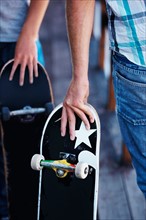 Close-up of men holding skateboardes