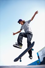 Skater performing jump in skateboard park