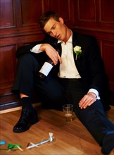 Drunk groom sitting on floor