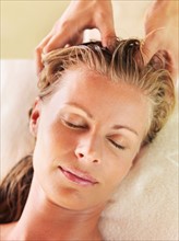 Mid adult woman receiving head massage