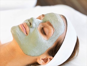 Woman with face mask relaxing in spa